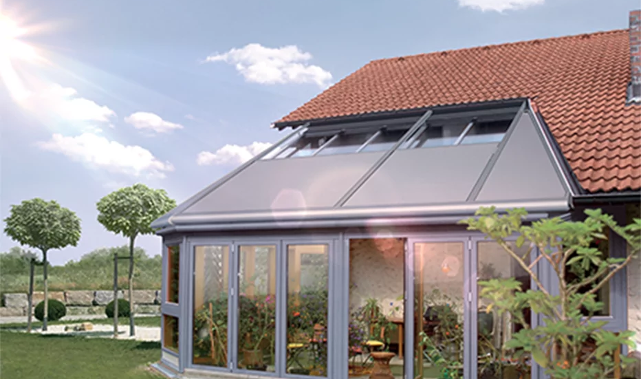 Ein Wintergarten mit großen Glasfronten an ein Haus angebaut.