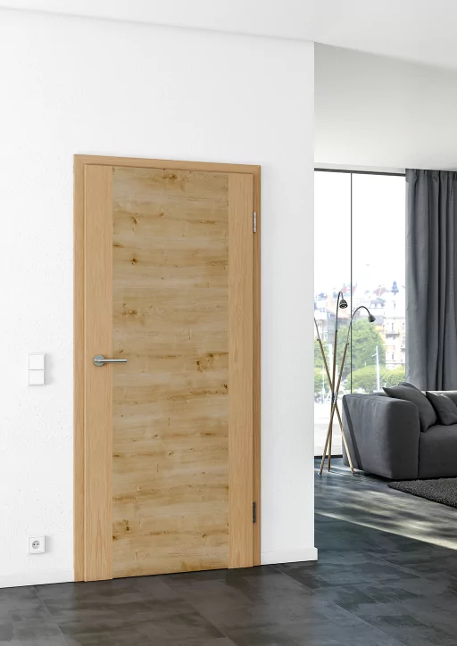 Eine Innentüre in natürlichem Holz-Look in einem Raum mit weißen Wänden und dunklem Boden und Möbeln.