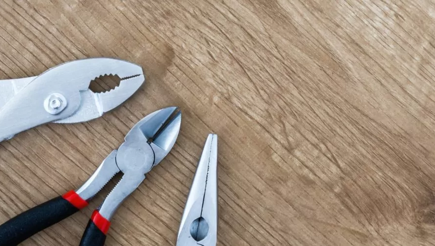 Verschiedene Zangen auf einem Holztisch